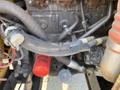 A close-up view of the engine components of a 2010 Vermeer Corporation BC1200XL including hoses and filters