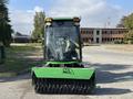 A 2021 John Deere 1575 with a front-mounted reel mower attachment and a cab, designed for lawn and turf maintenance