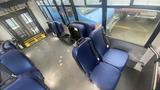 Interior view of a 2021 Ford Transit with blue upholstered seats and a safety sign visible on the wall