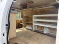 Interior of a 2008 Ford Econoline van featuring wooden shelves a storage area and a workbench setup on the floor