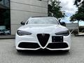 A 2023 Alfa Romeo Giulia in white with a distinctive front grille and sleek headlights facing directly forward