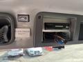 Interior dashboard of a 1999 Freightliner FL80 featuring a digital audio system and a sign labeled WATER COOLER BAG with visible wiring and buttons