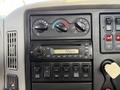 Dashboard of a 2011 International 7500 featuring climate control knobs a radio display and various control buttons for engine brake and air locks