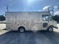 A 2009 Workhorse W62 delivery truck with a metallic exterior featuring side compartments and a large rear cargo area