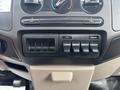 Dashboard controls of a 2009 Ford F-450 Super Duty featuring air conditioning knobs and multiple auxiliary switches