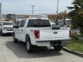 White 2021 Ford F-150 pickup truck viewed from the rear showing the bed and tailgate with the Ford logo and 4x4 badge