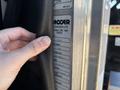 A hand is holding a black strap near a label on a metallic surface showing specifications for a 2020 Peterbilt 330 vehicle