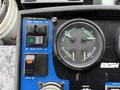 A control panel featuring various buttons and dials including left side controls for broom position and tilt along with gauges for temperature and pressure