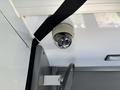 A round security camera mounted on the ceiling of a vehicle
