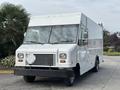 A 2018 Ford Econoline van with a boxy design featuring a flat front windshield large headlights and a blank diamond plate on the front grill