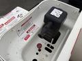 A close-up view of a 2020 International MV607 engine component featuring a black connector and safety warning labels