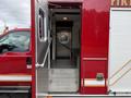 A 2007 Ford F-550 fire truck with an open rear door revealing a set of metal steps leading into the interior of the vehicle
