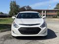 A white 2015 Hyundai Sonata facing forward with a sleek design and distinctive front grille