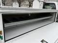 Interior storage compartment of a 2001 Ford F-350 with metal shelves and a smooth gray floor