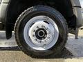 Close-up of a 2024 Ford F-550 wheel featuring a white rim and rugged tire treads designed for heavy-duty performance