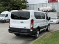A white 2017 Ford Transit T150 XLT van with a spacious rear and large windows parked with visible tail lights and a rear license plate area
