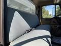 Interior view of a 1991 International 4600 showing a long gray upholstered bench seat with a seatbelt attached