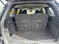 A 2015 Dodge Durango with its rear seats folded down revealing a spacious cargo area with a carpeted floor