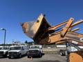 A 2011 Case 570 MXT construction loader with a raised bucket showing signs of wear and rust