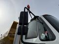 A 2016 International 7600 truck with a prominent side mirror and a red emergency light mounted on the roof