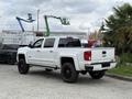A white 2017 Chevrolet Silverado 1500 pickup truck with black wheels parked at an industrial site