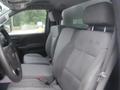 A gray interior of a 2015 Chevrolet Silverado 1500 showing two front seats with a steering wheel and headrests in view