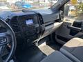 The interior of a 2019 Ford F-150 featuring a dashboard with a central display audio system climate controls and fabric seats