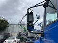 A blue 2013 International DuraStar 4300 truck with a large side mirror is positioned in the foreground