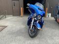 A 2017 Harley-Davidson FLHTKL motorcycle in blue with a windshield and chrome accents parked with its front facing forward