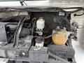 The image shows the engine compartment of a 2012 Ford Econoline with various components like the battery coolant reservoir and hoses clearly visible