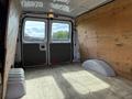 Interior view of a 2013 Ford Econoline van featuring wooden side panels and a minimalistic cargo space with a flat floor and two rear doors