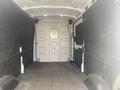 Interior of a 2024 Ford Transit van showing empty cargo space with black wall panels and a rear door