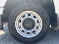 A close-up view of a tire mounted on a 2011 Chevrolet Colorado featuring a silver wheel with the Chevrolet logo and a rugged black tire tread