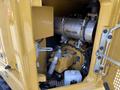 Close-up of the engine compartment of a 2022 Caterpillar 306 showcasing the engine components and plumbing details