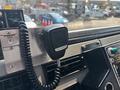 A close-up view of the microphone in a 1999 Freightliner FL80 truck cabin with a coiled cable attached
