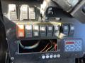 Dashboard controls of a 2013 Chevrolet Express featuring various switches and buttons for vehicle functions with visible wiring beneath