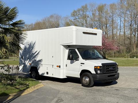 A white 2012 Ford Econoline E-450 box truck with a high roof and front headlights visible parked at an angle