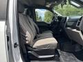 The interior of a 2017 Ford F-550 showing two front seats with patterned upholstery and a view of the dashboard and steering wheel