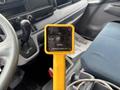 A yellow control panel with buttons labeled UP HOIST and DOWN held in a vehicle interior