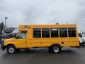 A yellow 2021 Ford Econoline bus with large windows and a high roof, designed for passenger transport