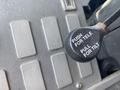 Close-up of a control lever labeled "PUSH FOR TELE PULL FOR TILT" mounted on a dashboard with several buttons around it