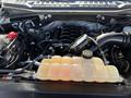 A 2018 Ford F-150 engine bay showcasing the engine components including the coolant reservoir and air intake system