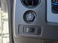 Control panel of a 2014 Ford F-150 featuring a dial for headlight settings and a switch for fog lights