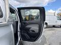A silver 2018 Chevrolet Colorado with an open driver's side door showcasing the interior door panel and handle