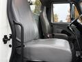A gray driver seat of a 2006 International 4200 truck with a second seat visible in the cabin area