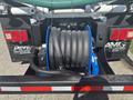 A 2022 Freightliner M2 106 with a blue hose reel mounted at the rear housing coiled black hoses and a connector attached