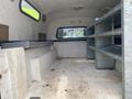 Interior of a 2014 Ford F-350 SD with empty metal shelves and long bench seating on one side