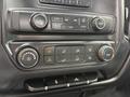 The control panel of a 2016 GMC Sierra 1500 featuring climate controls and audio system buttons with various knobs and switches