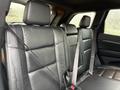 Black leather seats of a 2019 Jeep Grand Cherokee interior with seatbelts fastened