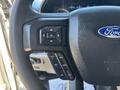 Close-up of a 2019 Ford F-550 steering wheel with control buttons including settings for cruise control and navigation
